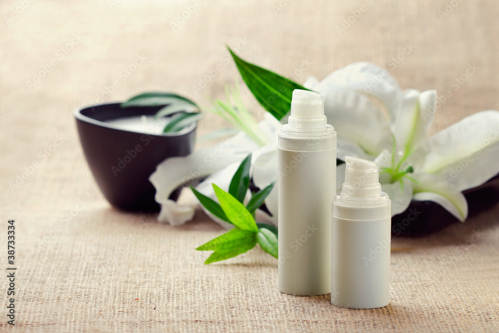 Bottles of creams/lotions/serums with lilys Bottles of creams/lotions/serums with lilys