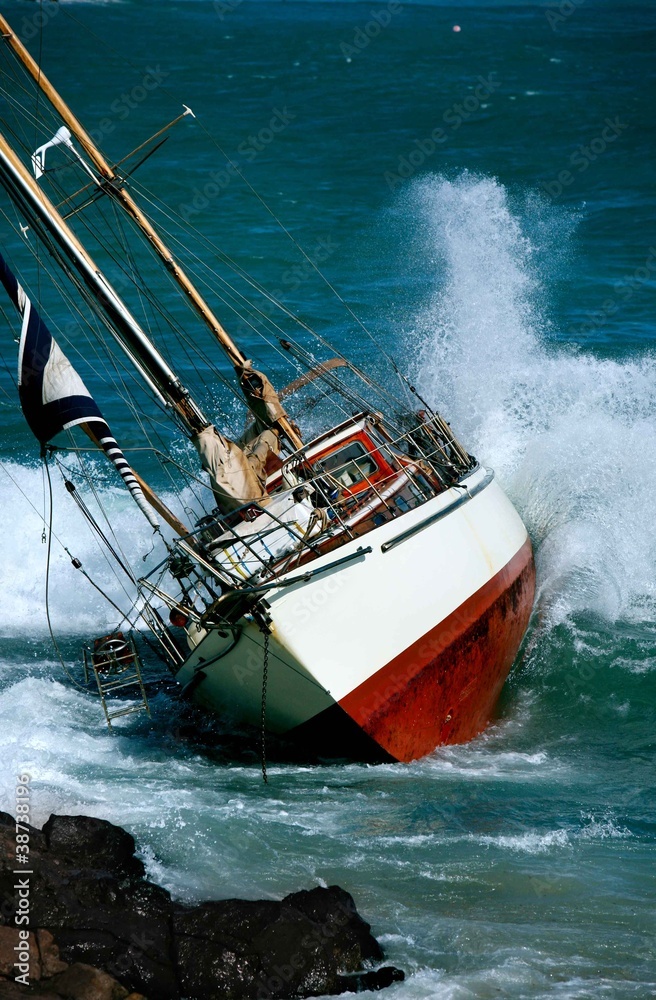 Naklejka premium yacht crash on the rocks in stormy weather