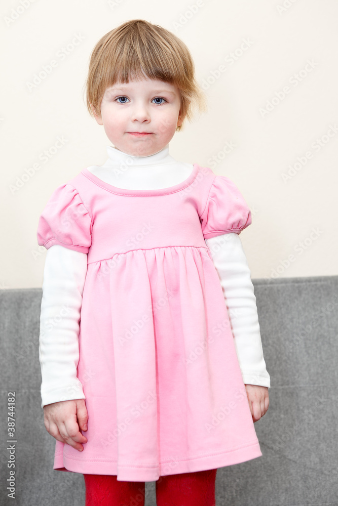 Portrait of small girl in pink dress standing on couch Portrait of small girl in pink dress standing on couch