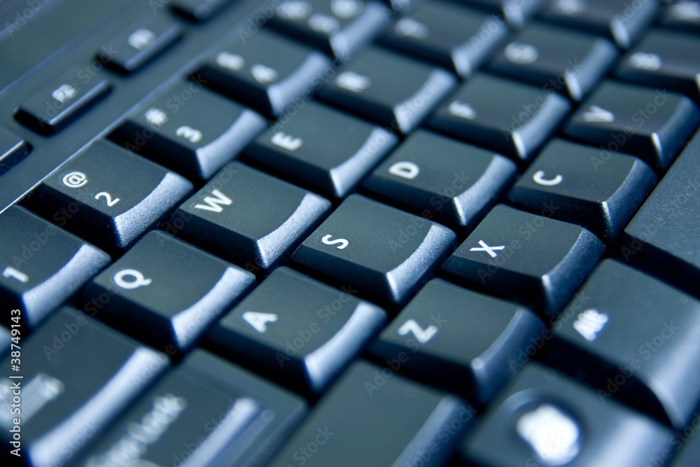 Closeup black computer keyboard, blue toned light Closeup black computer keyboard, blue toned light