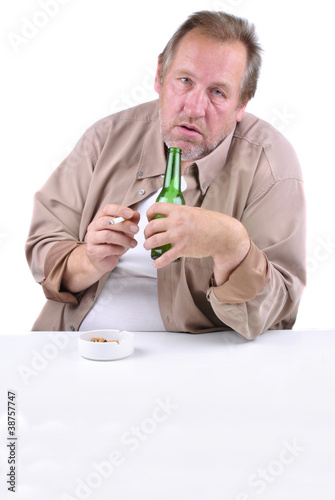 horrified man in his 50s sitting at a table with a beer