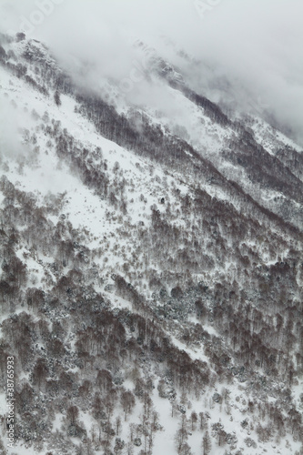 Parete di montagna con neve e nebbia.