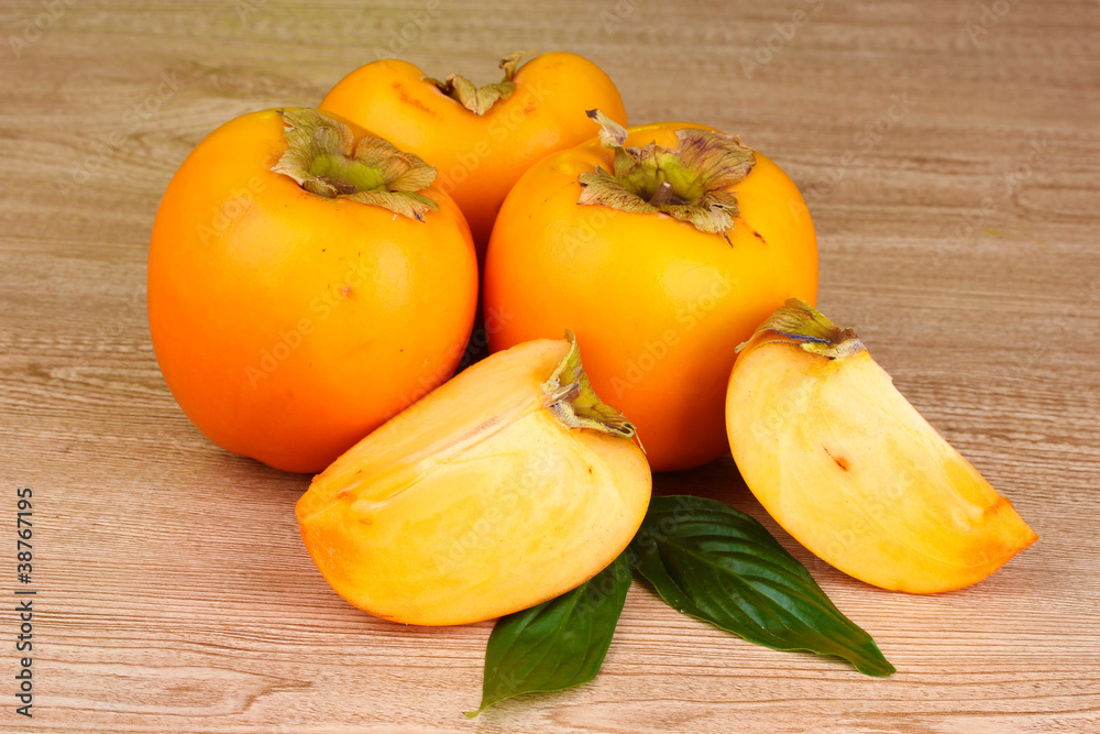 Appetizing persimmons on wooden background
