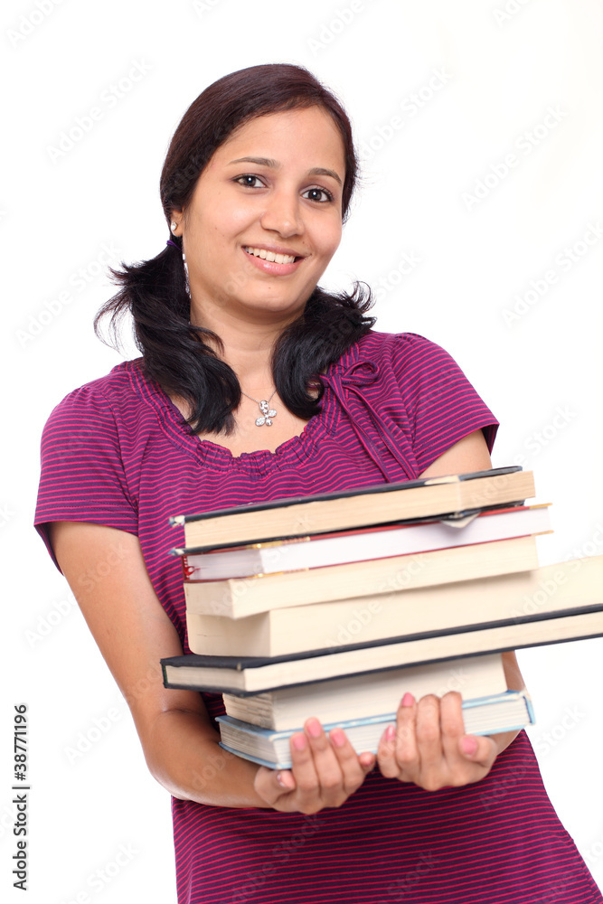 Female student making efforts to hold pile of books Female student making efforts to hold pile of books