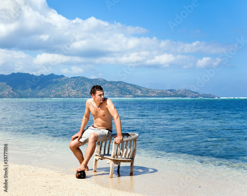 Young man in chair resting on the beach