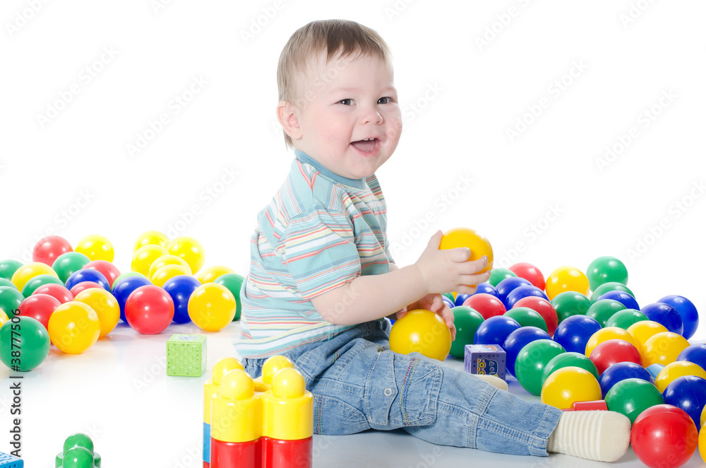 The little boy plays multi-coloured toys The little boy plays multi-coloured toys