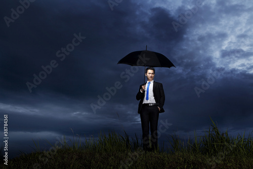 Businessman standing with umbrella © Creativa Images