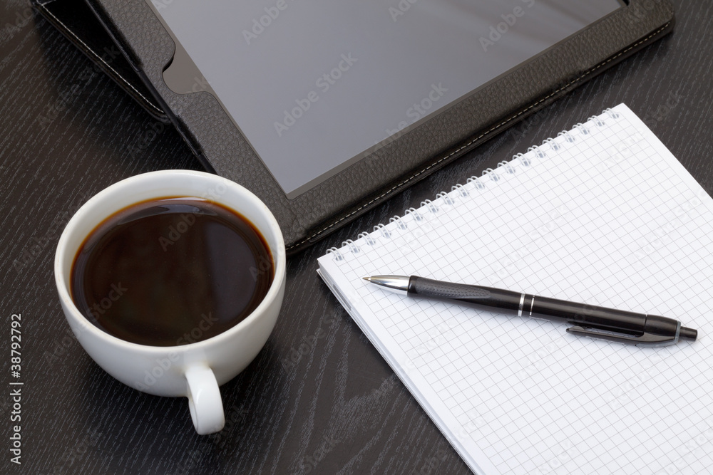 Coffee cup, tablet, spiral notebook and pen Coffee cup, tablet, spiral notebook and pen