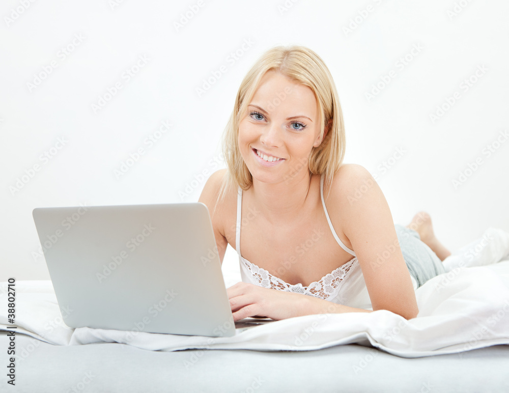Young beautiful woman using laptop in bed Young beautiful woman using laptop in bed
