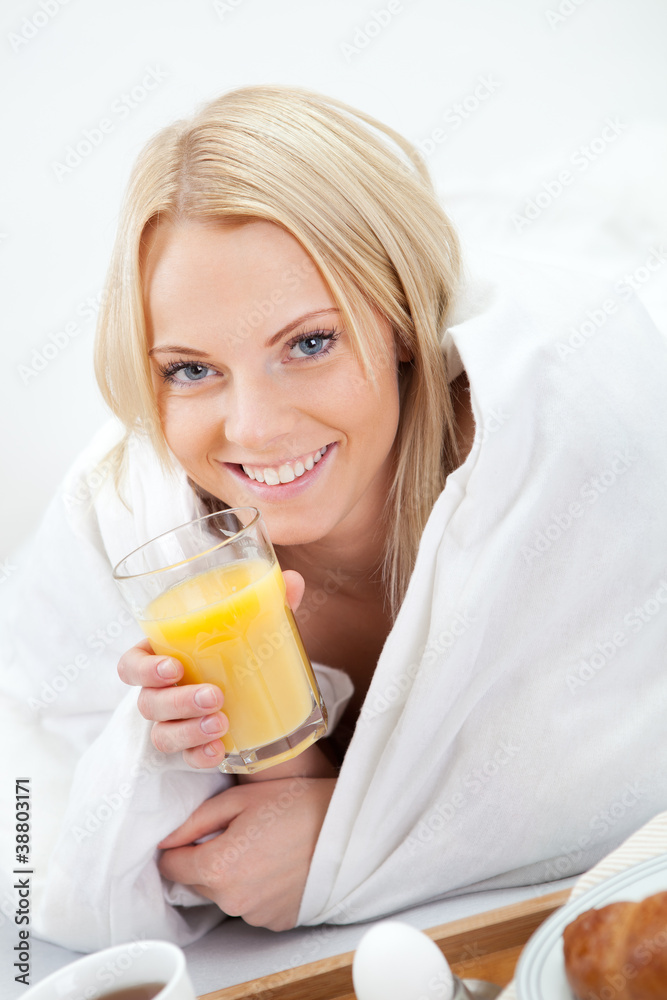 Beautiful woman drinking juice in bed Beautiful woman drinking juice in bed