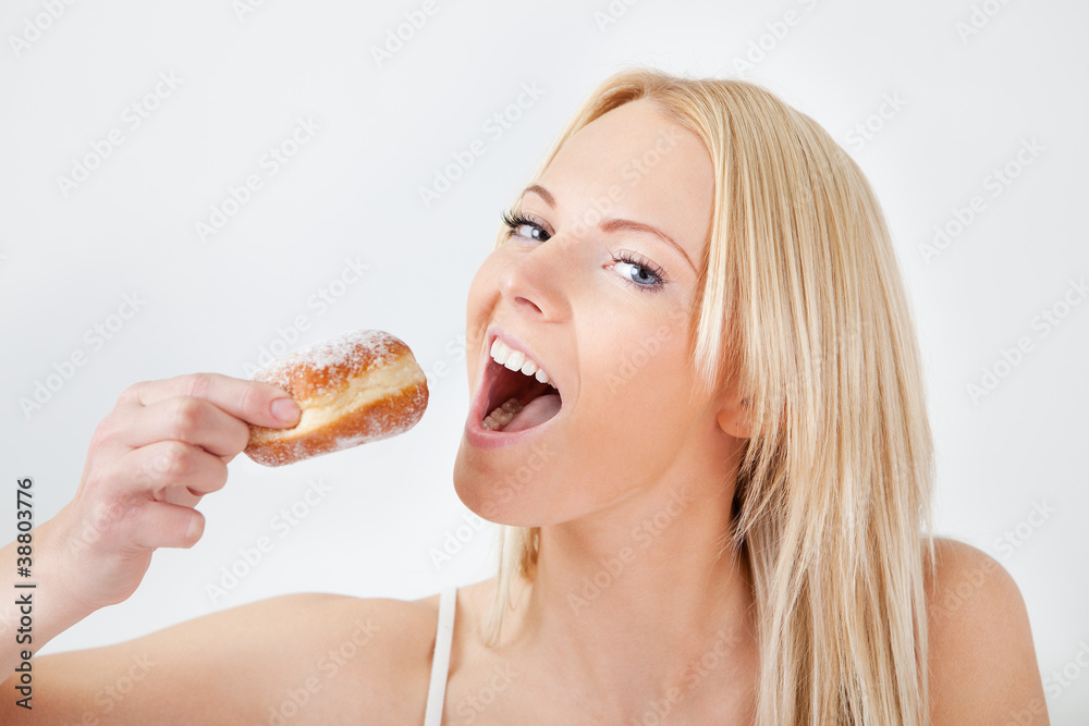 Beautiful woman eating tasty donut