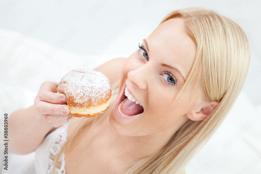 Beautiful woman eating tasty donut