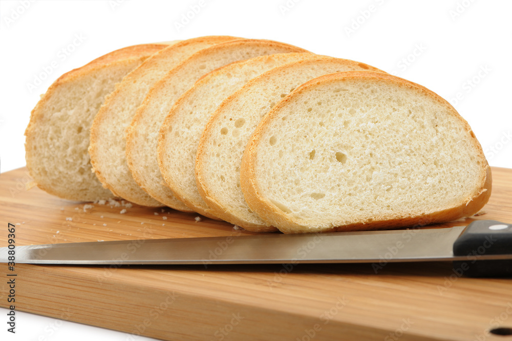 The cut bread on a chopping board with a knife