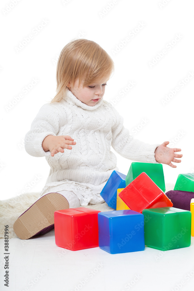 Baby girl plays with toy blocks over white background Baby girl plays with toy blocks over white background