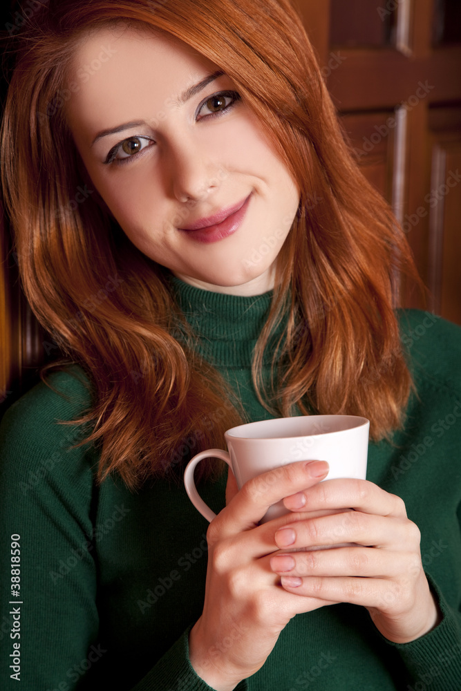 Style redhead girl drinking coffee near wood doors. Style redhead girl drinking coffee near wood doors.