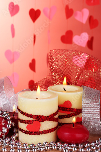 candles for Valentine s Day on wooden table on red background