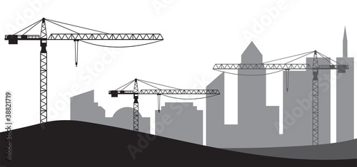Construction site, cranes and silhouette of the city