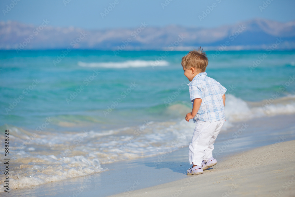 Young cute boy playing happily at pretty beach Young cute boy playing happily at pretty beach