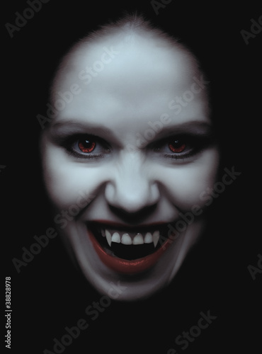 woman vampire with fangs on a black background