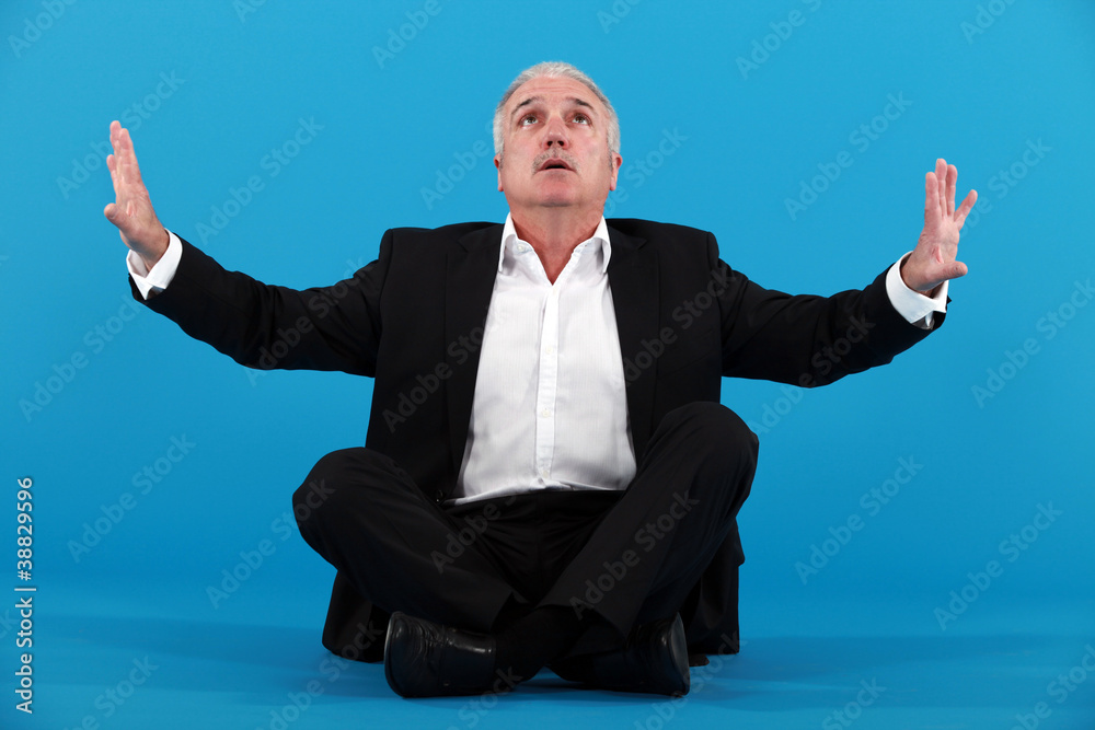 senior businessman sitting on the floor and looking upwards senior businessman sitting on the floor and looking upwards