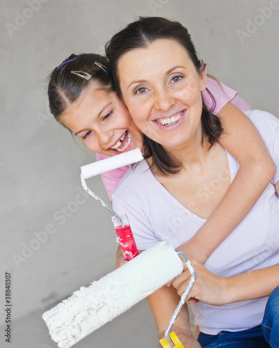 Happy Mother and douther painting a wall photo