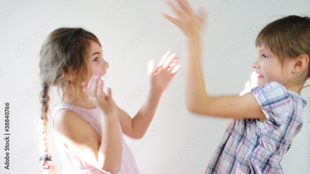 Two happy playful children laughing and playing pat-a-cake Two happy playful children laughing and playing pat-a-cake