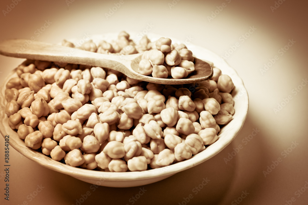 Chickpeas in a bowl and wooden spoon. Retro.