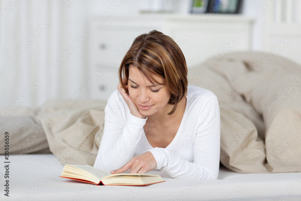 entspannte frau liest ein buch im bett entspannte frau liest ein buch im bett