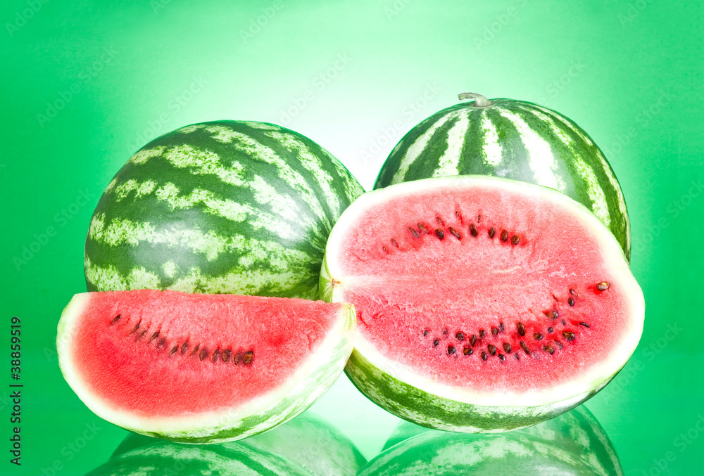 Two watermelon, half and Slice on a green background Two watermelon, half and Slice on a green background