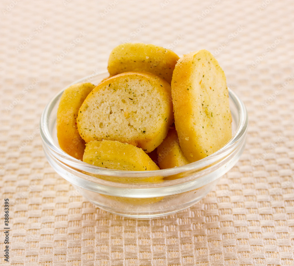 Appetizing rusks in bowl on beige napkin Appetizing rusks in bowl on beige napkin