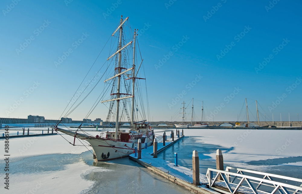 Tall ship in a frozen harbor in winter