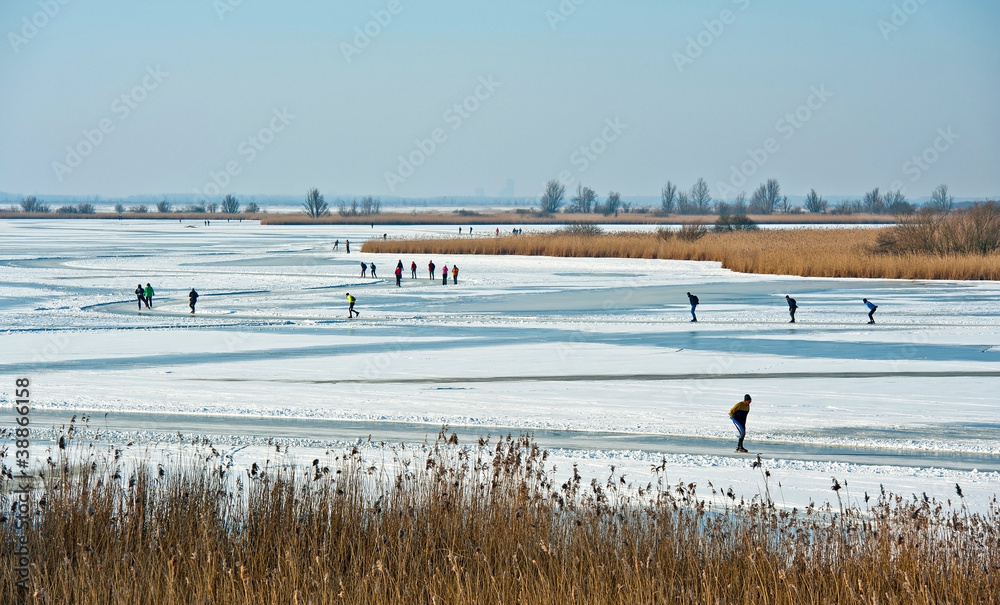 People skating on a frozen lake in winter