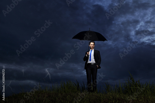 Businessman standing in thunderstorm © Creativa Images