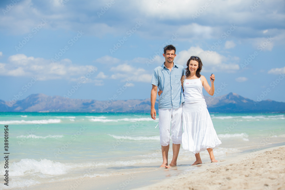 Happy young couple walking on beach Happy young couple walking on beach