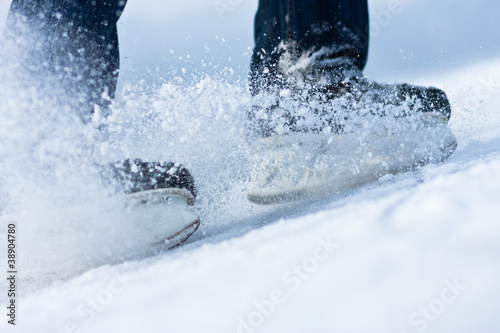 Two breaking ice skates with flying snow