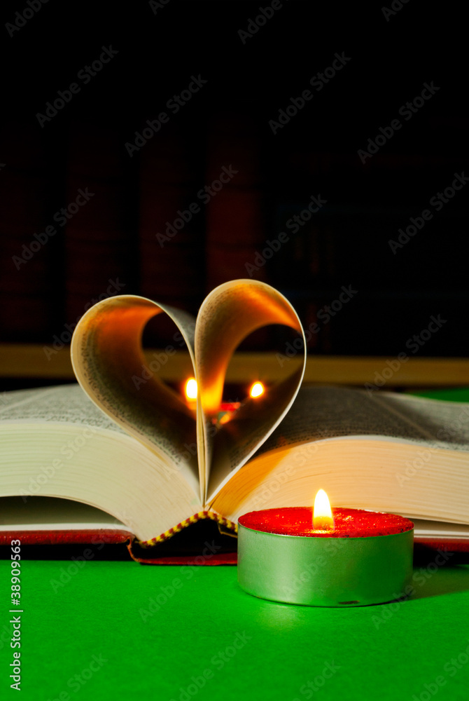 Open book with burning candle