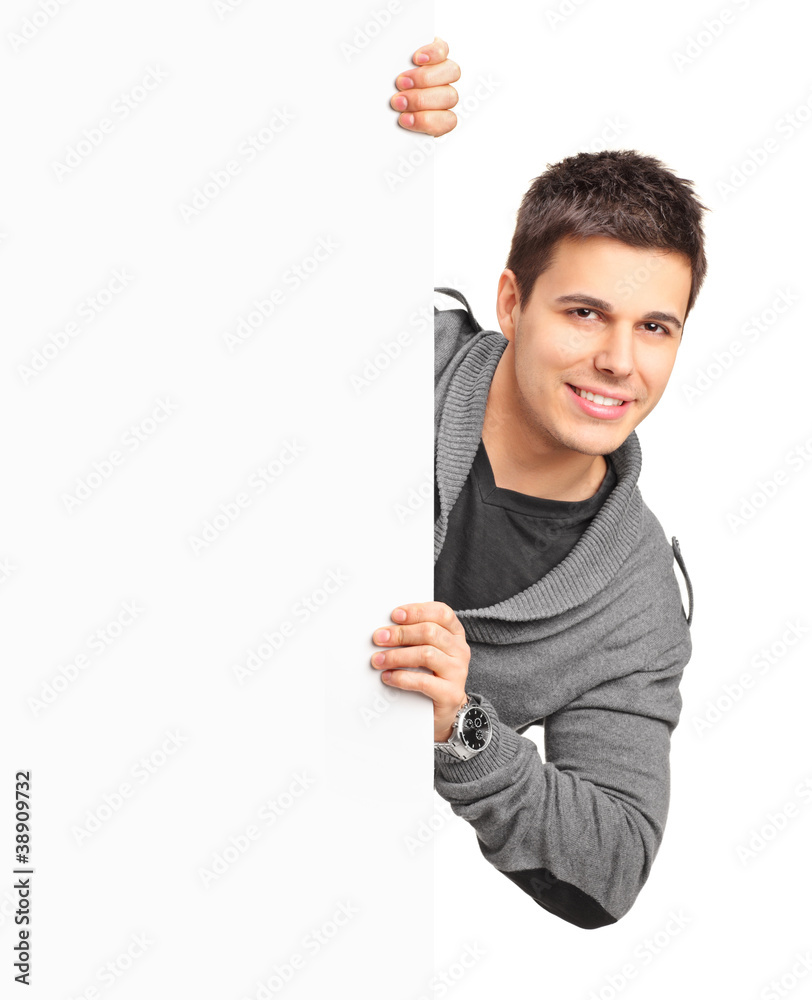 A smiling handsome male posing behind a white panel A smiling handsome male posing behind a white panel