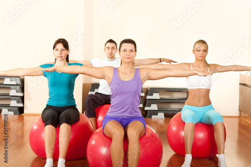 group of people doing  exercises on fitness ball