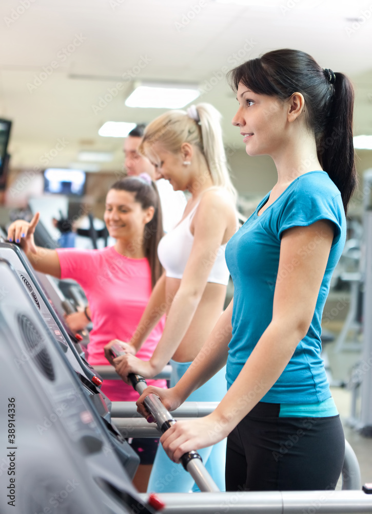 women in gym with personal trainer