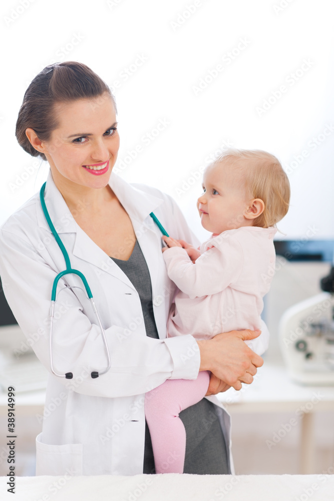 Happy pediatrician doctor with baby on examination Happy pediatrician doctor with baby on examination