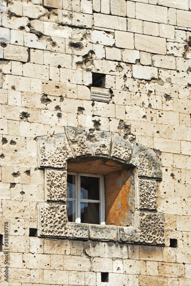 Shattered wall with cracks and bullet holes