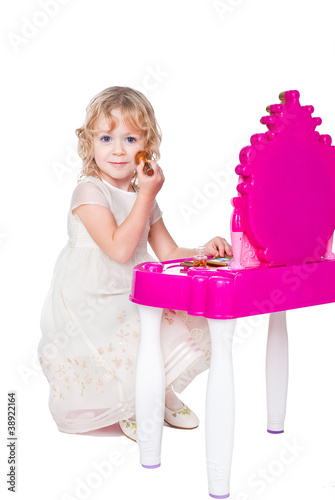 little girl playing with makeup isolated on white background