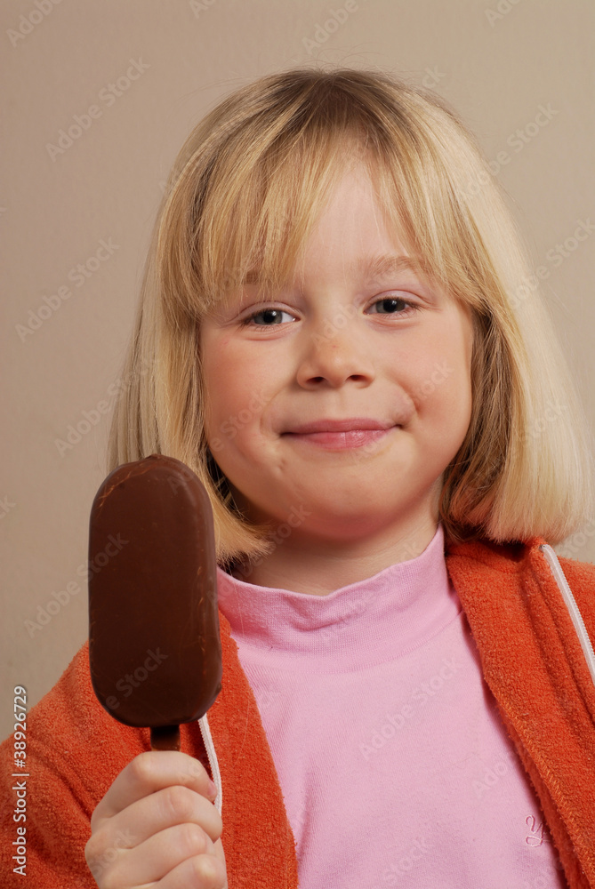 Niña comiendo una paleta de helado de chocolate. Photos | Adobe Stock