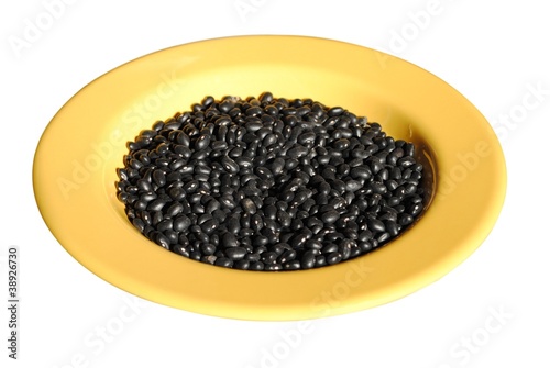 black beans in a yellow dish isolated on white