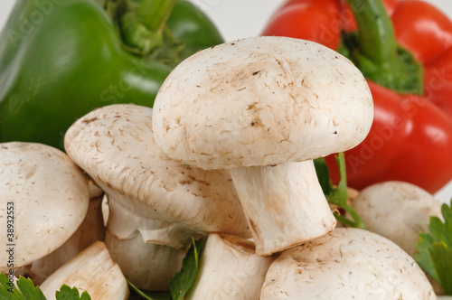 Tasty fresh white mushrooms with peppers on background