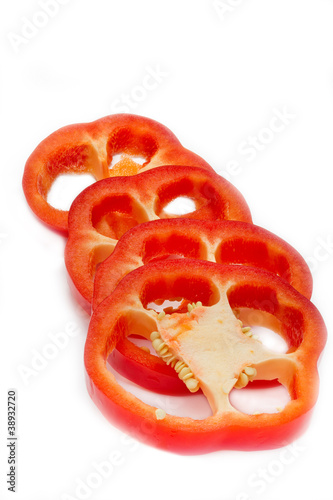 In Ringe geschnittene rote Paprika auf weißem Hintergrund