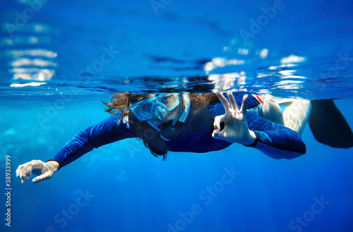 Scuba diver woman in blue water.