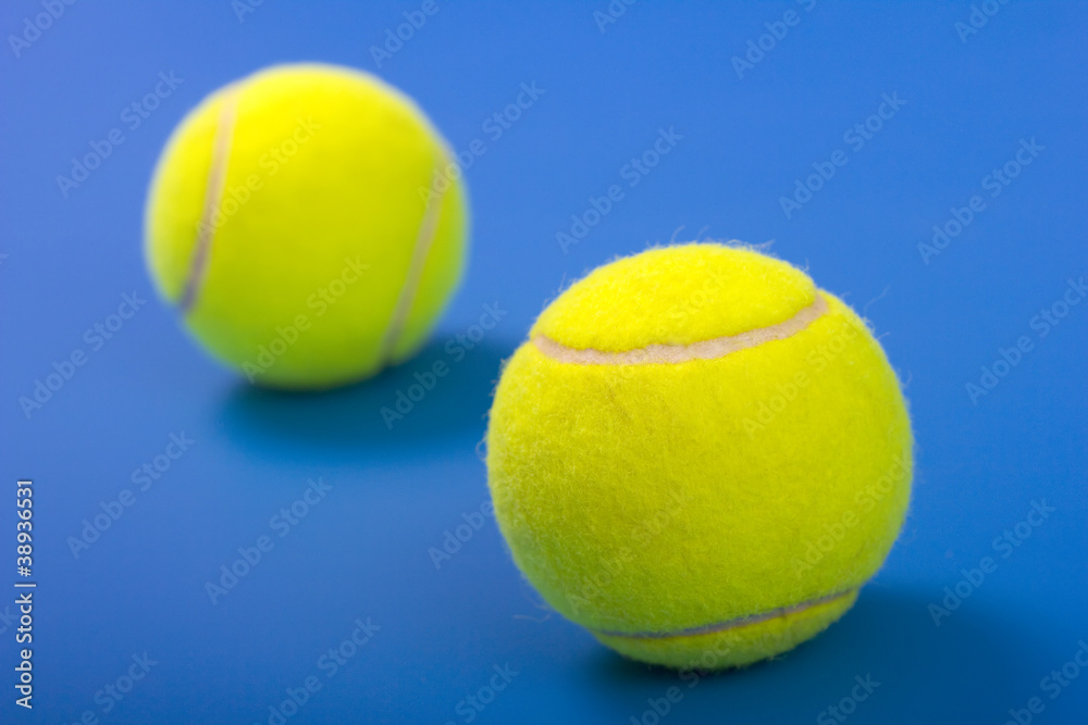 Two tennis balls on a blue background