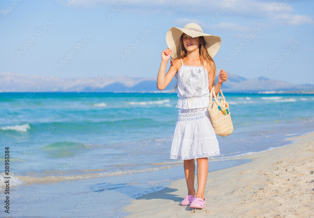 Adorable girl wearing elegant hat on the beach