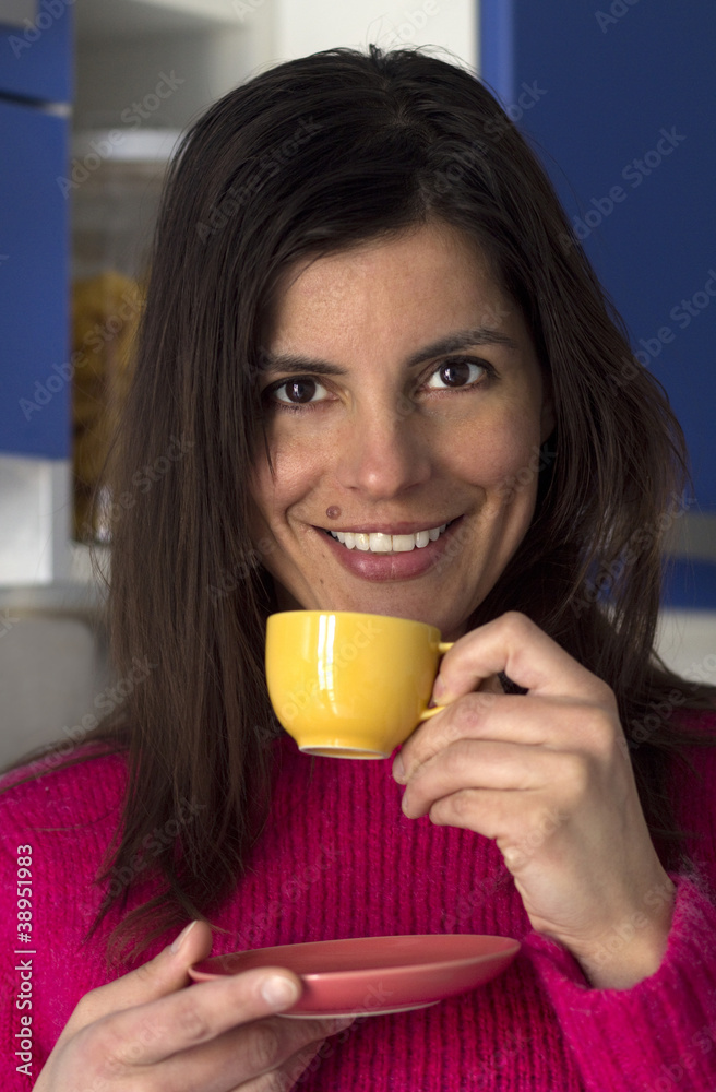 brunette smiling woman drinks a cup of coffee